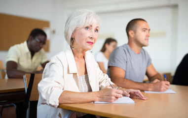 Obraz premium Mature woman with other adult different ages students in studying with their colleagues