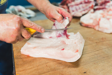 close-up of meat processing in the food industry, the worker cuts raw pig. High quality photo