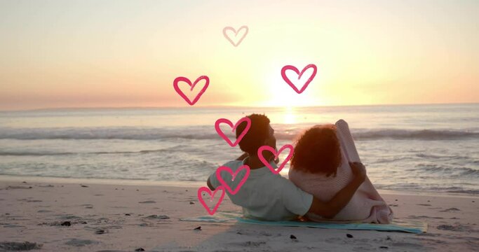 Animation of hearts moving over diverse couple in love embracing on beach in summer