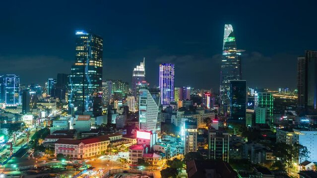 Timelapse view of Ho Chi Minh City (Saigon), Vietnam, showing landmark buildings and traffic in the financial district at night, zoom out. 