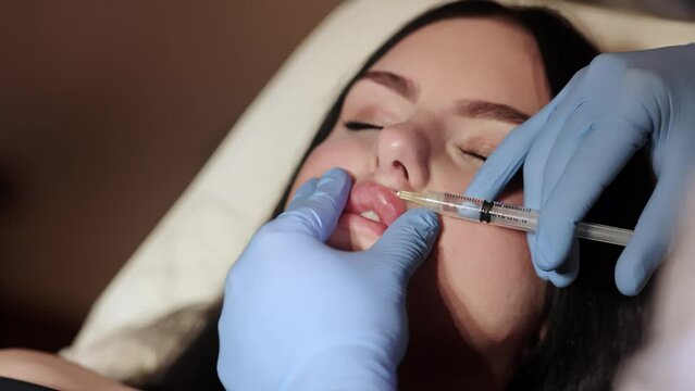 The doctor cosmetologist makes Lip augmentation procedure of a beautiful woman in a beauty salon.Cosmetology skin care. High quality photo