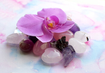 Obraz na płótnie Canvas Beautiful amethyst crystals and orchid flower. Healing crystals, the magic of precious stones.