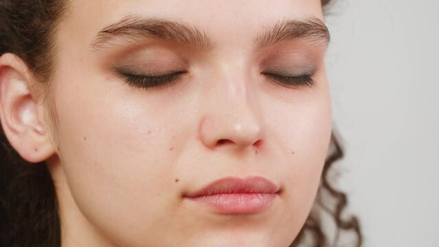 Eye shadow makeup to the upper eyelid, close-up. Makeup artist applies a bright eye shadow with a make-up brush.Tutorial master class of professional makeup, smoky eyes 