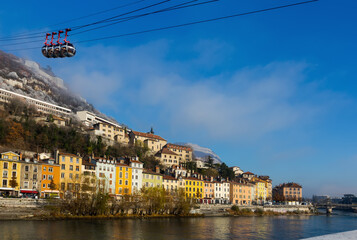 Image of cable cars in Grenoble in autumn over riverside, France.