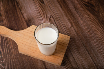 Milk glass isolated on wooden background. Copy space.