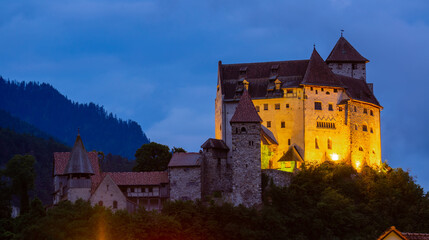 Naklejka premium Night view of illuminated medieval Gutenberg Castle on hilltop in Balzers village on summer, Liechtenstein