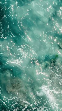 Top view of calm and clean blue and green water with reflections of the sun