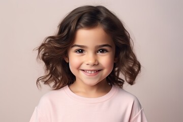 Portrait of a cute little girl with curly hair, studio shot