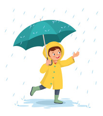 Cute little boy wears raincoat holding umbrella playing in the rain
