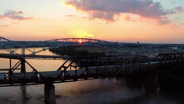 Aerial Forward Scenic View Of Famous Bridge Over Rippled River Under Cloudy Sky During Sunset - Buckner, California