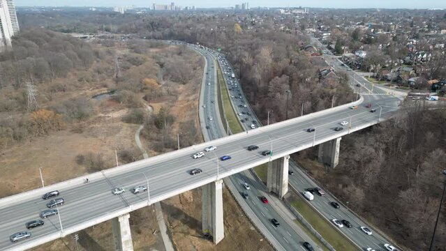 This 4K drone shot shows the rush hour traffic on the Don Valley Parkway passing under the Leaside bridge in Toronto Canada.