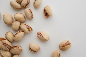 Roasted and salted pistachios in shell on white background