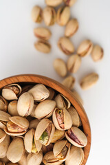 Roasted and salted pistachios in shell on white background
