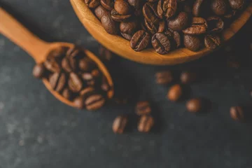 Keuken foto achterwand Koffiebar Coffee beans in a wooden plate on a black background