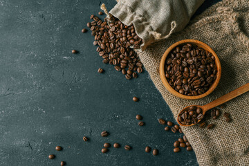Coffee beans in a wooden plate on a black background