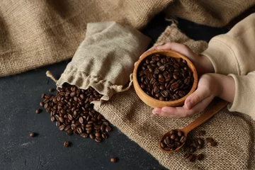 Fotobehang Coffee beans in a wooden plate on a black background © shine.graphics