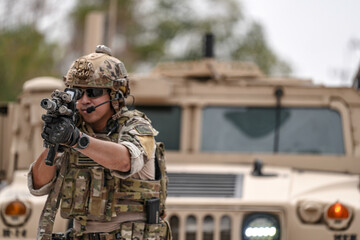 Confident soldier in full gear stands before a military vehicle, rifle in hand, showcasing...