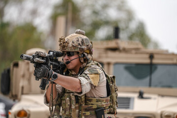 Confident soldier in full gear stands before a military vehicle, rifle in hand, showcasing...