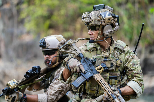 Soldiers in tactical gear aiming guns during a military exercise, showcasing teamwork and defense strategies.