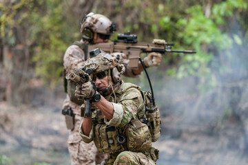 Fototapeta premium Soldiers in tactical gear aiming guns during a military exercise, showcasing teamwork and defense strategies.