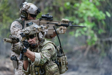 Fototapeta premium Soldiers in tactical gear aiming guns during a military exercise, showcasing teamwork and defense strategies.
