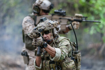 Fototapeta premium Soldiers in tactical gear aiming guns during a military exercise, showcasing teamwork and defense strategies.