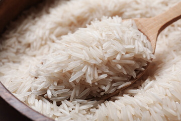 Raw basmati rice in bowl and spoon, closeup