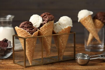 Tasty ice cream scoops in waffle cones on wooden table, closeup