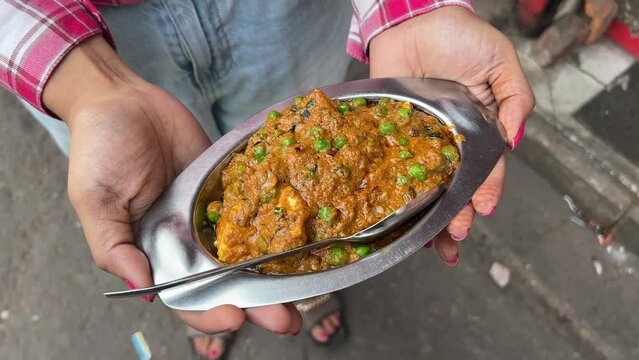 Traditional vegetarian curry paneer matar sabji masala held by a girl. No face video