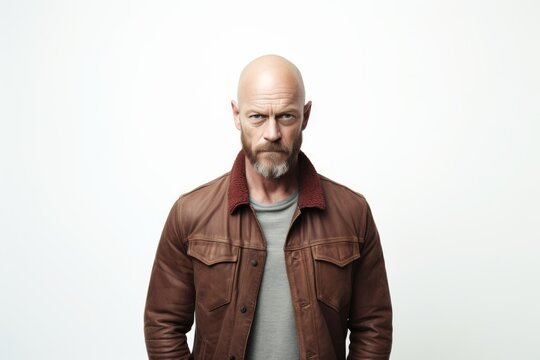 Portrait of a bald man with a beard in a brown jacket on a white background