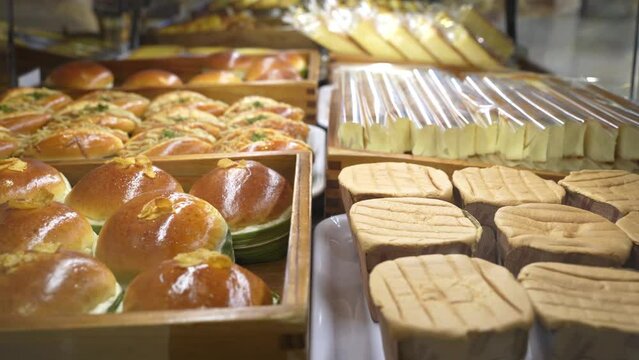Assorted pastry and bread arranged on tray selling at bakery shop.