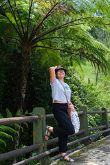 Woman taking a break under forest fern, during morning walk © Simon