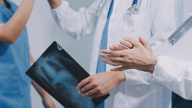 Qualified woman doctor in white uniform checking x-ray film, diagnose patient injury, smiling calm and standing isolated on studio background with copy space. Healthcare and medical insurance concept
