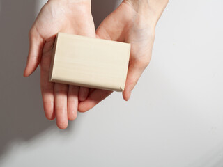 female women washing her hand with soap on grei gradient background. laundry soap in hand