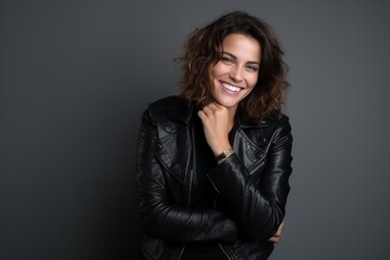 Portrait of a beautiful young woman in leather jacket smiling at camera