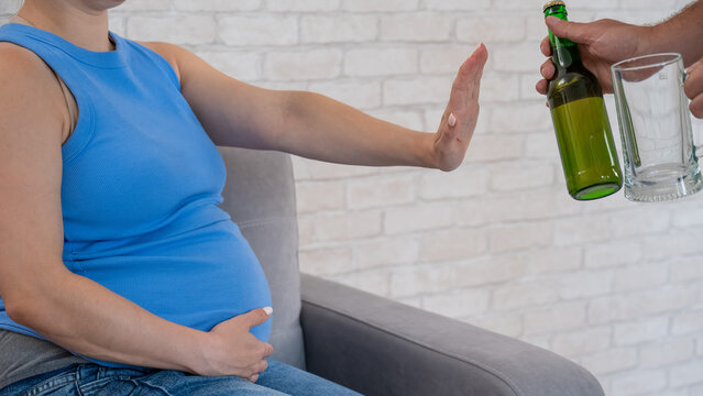 A pregnant woman refuses beer.