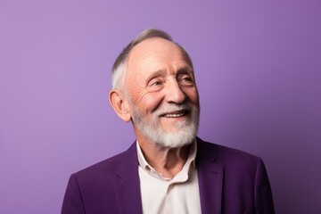 Portrait of happy senior man with grey hair and beard. Isolated on purple background.