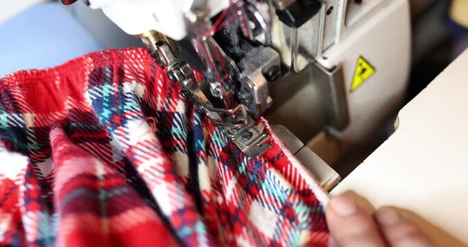 Dressmaker using overlock machine to secure fabric edges