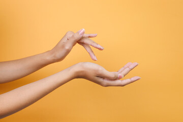 Beautiful Hands Applying Cream, Massaging, Isolated on Yellow Background