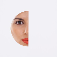 Woman, face and beauty in a cutout and studio for cosmetics, skincare and dermatology. Portrait of a young model with makeup, foundation and art deco, closeup or mockup space on a white background