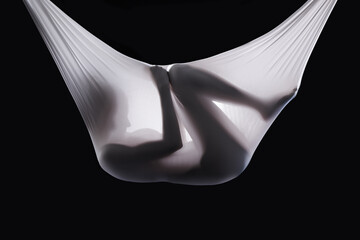 Person, fabric and wrapped naked in studio, abstract and creative art on black background. Woman, girl and material for ethereal or phantom ghost, bare and nude in sheet for fetus illusion in cloth - obrazy, fototapety, plakaty