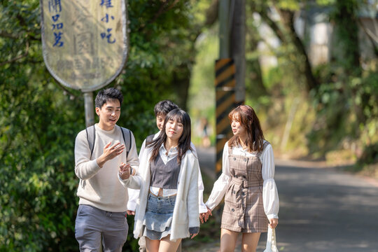 Four Taiwanese college students eat soft serve ice cream in the nature of Maokong, a tourist attraction in Wenshan District, Taipei City, Taiwan 台湾台北市文山区の観光名所の猫空の自然の中でソフトクリームを食べる台湾人の大学生の男女四人