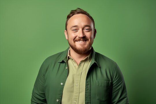 Portrait of a smiling man in a green shirt on a green background