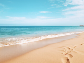 Tranquil beach with footprints in golden sand under clear skies