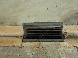 Water sewage, iron grid. Rusty and damaged metal grate installed at the local road.