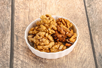 Cracked unshelled walnut in the bowl