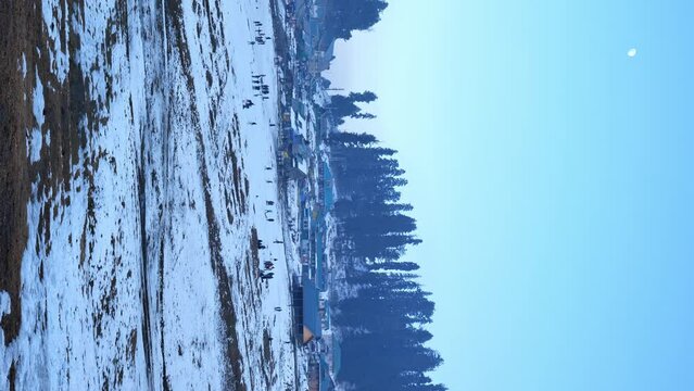 aerial view of gulmarg in winter with snow in jammu and kashmir, india. vertical pan  shot 4k
