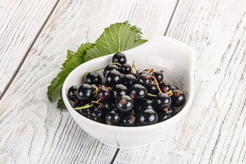 Juicy black currant berries in the bowl