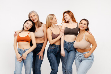 Group of smiling beautiful women friends hugging, wearing sexy bras and jeans, fashion models