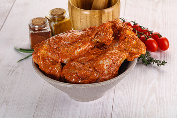 Raw turkey shoulder wing in Indian tandoori marinade